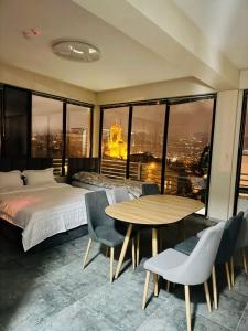 a bedroom with a bed and a table and chairs at Apartment Natali Inn in Tbilisi City