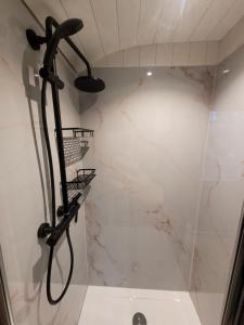 a shower with a black shower head in a bathroom at B&B 't Maartensdijkse Bos in Maartensdijk +16 photos