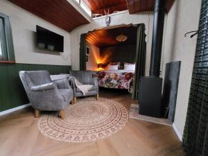 a living room with a room with a bed and a rug at B&B 't Maartensdijkse Bos in Maartensdijk