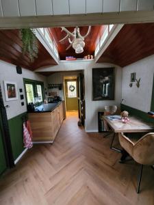 a living room with a wooden floor and a ceiling at B&B 't Maartensdijkse Bos in Maartensdijk