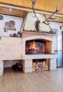 a large stone fireplace in a living room at Perla Guest House in Dospat