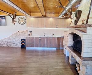 a large kitchen with a stone fireplace in a room at Perla Guest House in Dospat +34 photos