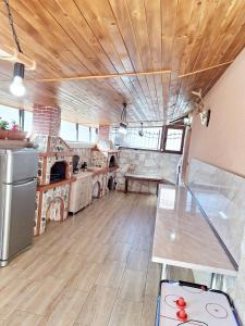 a large kitchen with a table and a stove at Perla Guest House in Dospat