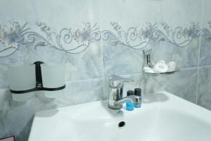 a white sink in a bathroom with a wall at Rasulboy Guest House in Khiva +89 photos