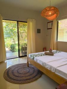 a bedroom with a bed and a large window at Happy Coconut Camiguin in Mambajao