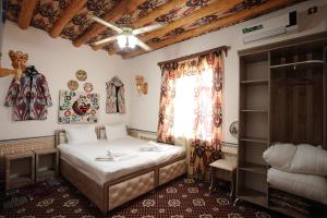 a small bedroom with a bed and a window at Rasulboy Guest House in Khiva