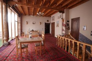a room with a table and chairs in a building at Rasulboy Guest House in Khiva