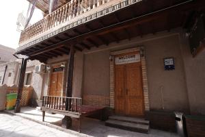 a building with two wooden doors and a sign on it at Rasulboy Guest House in Khiva