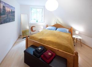 a bedroom with a large bed with a yellow blanket at Heideidyll - Wohnung mit WLAN, Balkon, Grill & Garage in Schneverdingen