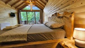 a bedroom with a bed in a log cabin at Chalet Jezerca in Valbonë
