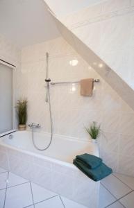 a bathroom with a bath tub with a shower at Heideidyll - Wohnung mit WLAN, Balkon, Grill & Garage in Schneverdingen
