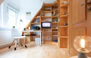 an attic room with a staircase with shelves and a desk at Heideidyll - Wohnung mit WLAN, Balkon, Grill & Garage in Schneverdingen