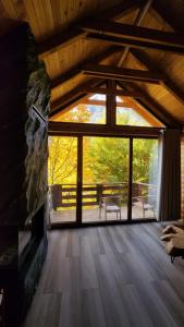 a large room with a large window in a cabin at Chalet Jezerca in Valbonë