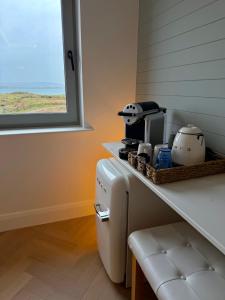 a small kitchen with a counter with a table and a counter at Connemara Sands Hotel & Spa in Clifden