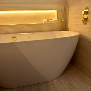 a white bath tub in a bathroom with a window at Connemara Sands Hotel & Spa in Clifden