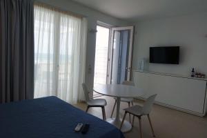 a bedroom with a bed and a table and chairs at Hotel e Residence Il Faro Acciaroli in Acciaroli