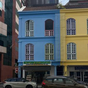 a blue building with cars parked in front of it at First Avenue Male Hostel BSB in Bandar Seri Begawan