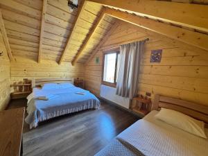 a bedroom with two beds in a log cabin at magiy cotteg in Rozhanka Nizhnyaya +70 photos
