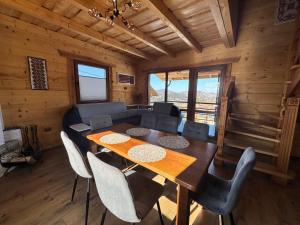 a dining room with a table and chairs in a cabin at magiy cotteg in Rozhanka Nizhnyaya