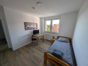 a bedroom with a bed and a desk with a computer at Ferienwohnung Gästehaus Bauer 1 in Heiligenhaus