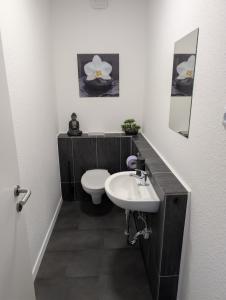 a bathroom with a white toilet and a sink at Ferienwohnung Gästehaus Bauer 1 in Heiligenhaus