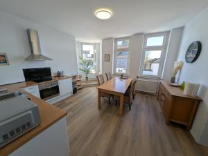 a living room with a table and a kitchen at Ferienwohnung Gästehaus Bauer 1 in Heiligenhaus