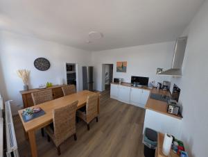a kitchen and dining room with a wooden table and chairs at Ferienwohnung Gästehaus Bauer 1 in Heiligenhaus +7 photos
