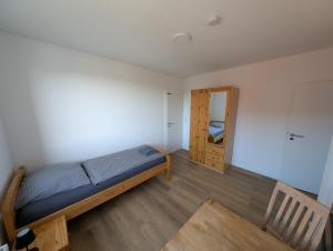 a small bedroom with a bed and a mirror at Ferienwohnung Gästehaus Bauer 1 in Heiligenhaus