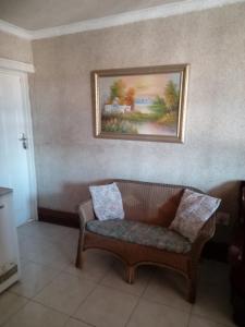 a couch in a room with a painting on the wall at Nkotsha The Palace in Diepkloof