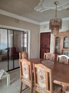 a dining room with a wooden table and chairs at Nkotsha The Palace in Diepkloof