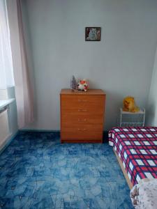 a bedroom with a bed and a dresser with a dresser at Butas in Gaveikėnai