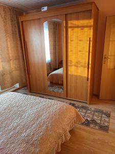 a bedroom with a large glass door with a mirror at Butas in Gaveikėnai