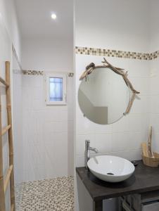 a bathroom with a sink and a mirror at charmante maisonnette avec spa privatif in Zonza
