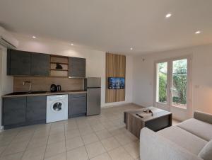 a kitchen and living room with a couch and a table at charmante maisonnette avec spa privatif in Zonza