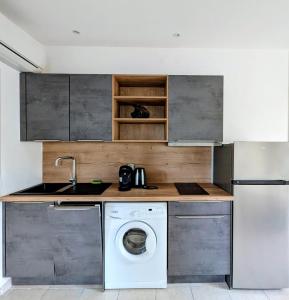 a kitchen with a washing machine and a washer at charmante maisonnette avec spa privatif in Zonza +5 photos