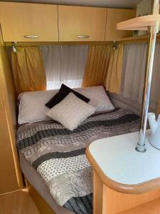 a small bed in the back of a caravan at Karavan Pod Lipami in Dolní Bečva