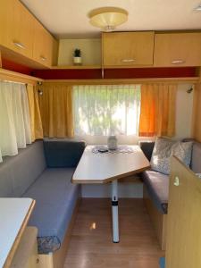 a small table and couch in a tiny caravan at Karavan Pod Lipami in Dolní Bečva