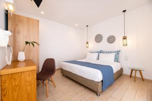 a bedroom with a bed and a desk and a chair at Evnia apartments in Vóthon