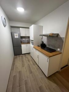 a kitchen with white cabinets and a wooden floor at Private Room in the Heart of Tallinn in Tallinn