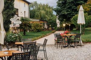 a group of tables and chairs with an umbrella at Agriturismo Le Caldane in Colà di Lazise