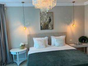 a bedroom with a bed and a chandelier at Vila DLK in Mamaia Sat/Năvodari +26 photos