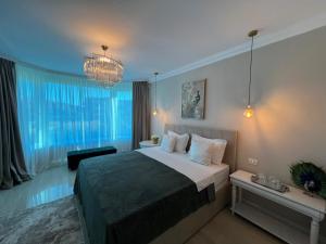 a bedroom with a large bed and a chandelier at Vila DLK in Mamaia Sat/Năvodari