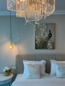a bedroom with a bed with a chandelier at Vila DLK in Mamaia Sat/Năvodari