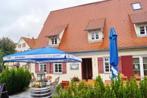 a blue umbrella in front of a building at Pension Webstuhl in Deizisau