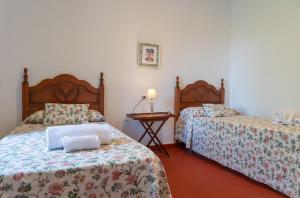 a hotel room with two beds and a table at Cortijo el Vicario in Ronda
