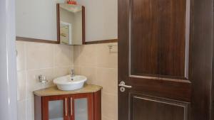 a bathroom with a sink and a wooden door at 7 Topanga in Uvongo Beach +46 photos