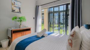 a bedroom with a bed and a large window at 7 Topanga in Uvongo Beach