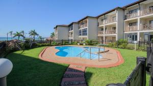 an apartment complex with a swimming pool in the yard at 7 Topanga in Uvongo Beach