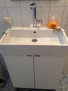 a white sink with a faucet in a bathroom at Ferienwohnung im Ferienhaus Kästner in Friedrichskoog +7 photos