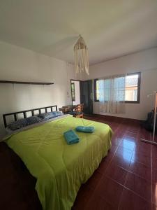 a bedroom with a green bed and a chandelier at Honey Zen Zone in Ko Mak